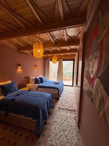 a bedroom with two beds and a painting on the wall at La Perle de Neige in Imlil