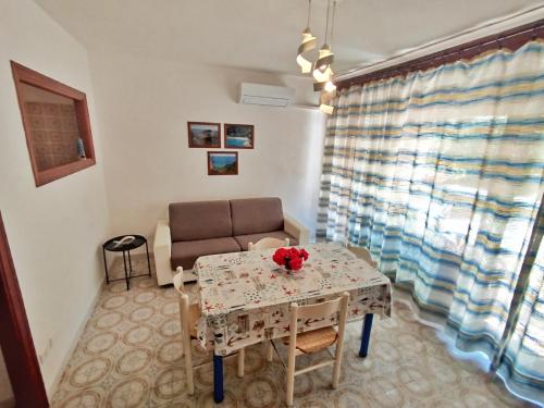 a small living room with a table and a chair at Giglio Gold in Giglio Porto