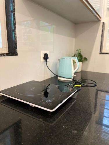 a laptop sitting on a counter with a tea kettle at Trinity Villa Home Stay in Idukki