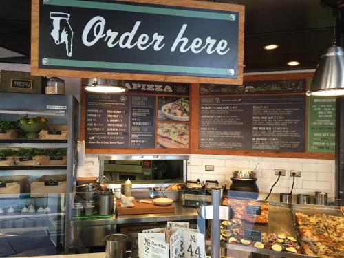 a fast food restaurant with a sign that reads order here at La Pensione Hotel in San Diego