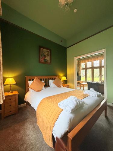 a bedroom with two beds and a green wall at The Old Lodge in Malton