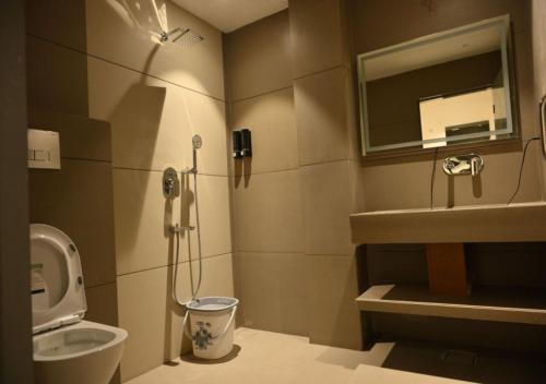 a bathroom with a shower and a toilet and a sink at Hotel Abhilasha Premium in Dewās