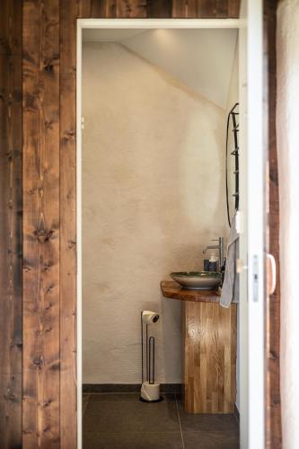a bathroom with a door leading to a sink at Windmill with the best sunset view in Borgholm
