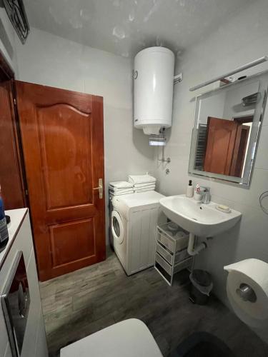 a bathroom with a sink and a toilet and a mirror at Plavi apartman Airport in Belgrade