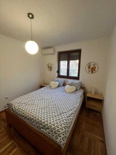 a bedroom with a bed with two pillows on it at Plavi apartman Airport in Belgrade