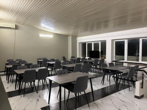 a large room with tables and chairs and windows at Nana Grand Hotel Yerevan in Yerevan
