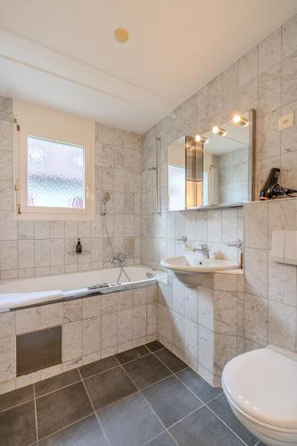 a bathroom with a tub and a toilet and a sink at Copper Suite · Seebach in Zurich