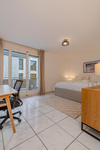 a bedroom with a bed and a desk and a table at Copper Suite · Seebach in Zurich