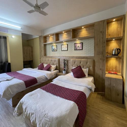 a hotel room with two beds and a ceiling at Hotel Sambridhi in Panepa