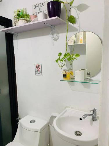 a bathroom with a toilet and a sink and a mirror at Calm & Cozy Hideaway in Tunkong Manga