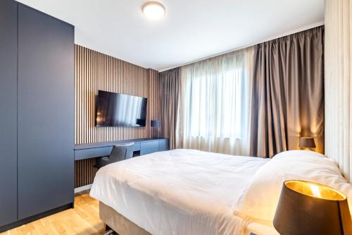 a hotel room with a bed and a flat screen tv at Arena Lux Apartments in Zagreb