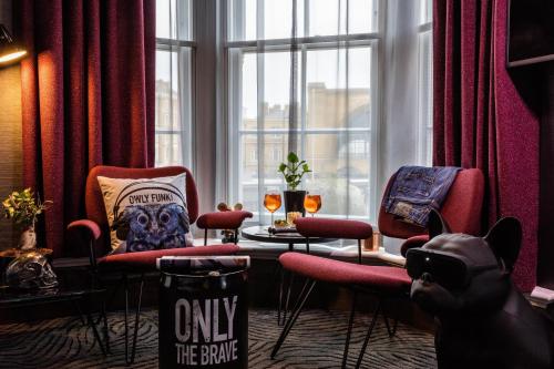 a person taking a picture of a room with chairs and a table at The Megaro Hotel - Kings Cross St Pancras, London in London