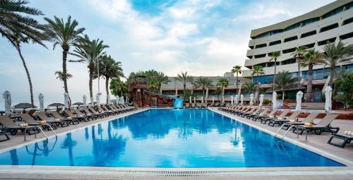 a pool at the resort with chairs and a slide at Occidental Sharjah Grand in Sharjah