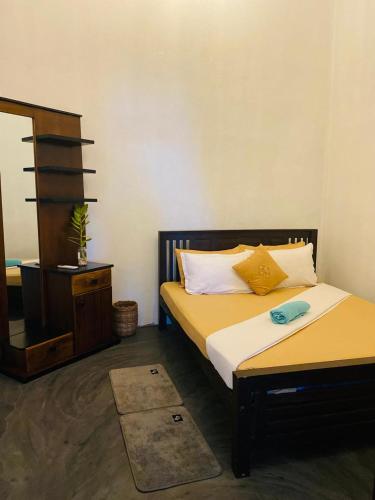 a bedroom with two beds and a dresser and a mirror at Rilu Surf Stay Arugambay in Arugam Bay