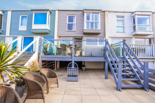 a house with a blue deck with chairs at Sea View 3 bedroom seaside property in Chichester