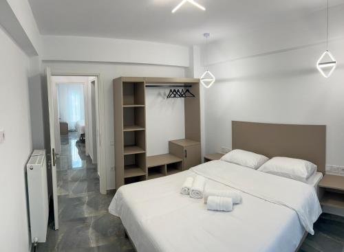 a bedroom with a large white bed with towels on it at MARRONI RETREAT - Pool - Spa - Gym in Skotina