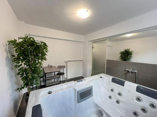 a large white bath tub in a room with plants at MARRONI RETREAT - Pool - Spa - Gym in Skotina