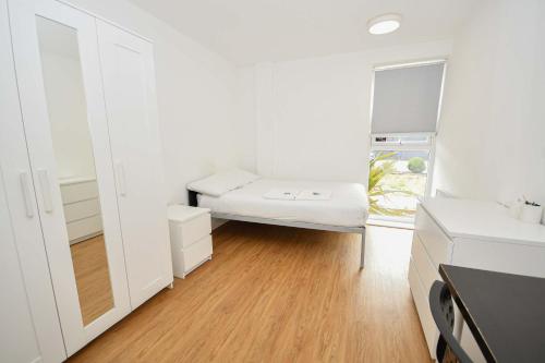 a small white room with a bed and a window at Budget En-suites Optional Kitchen Liverpool in Liverpool