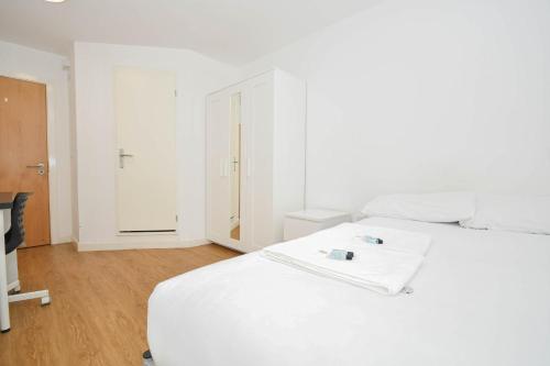a white bedroom with a white bed and a television at Budget En-suites Optional Kitchen Liverpool in Liverpool