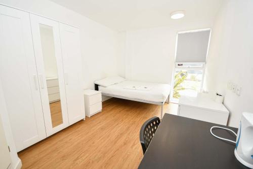 a white room with a table and a mirror at Budget En-suites Optional Kitchen Liverpool in Liverpool