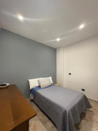 a bedroom with a bed and a wooden table at Appartamento Accogliente tra Borghi e Natura in Castelluccio dei Sauri