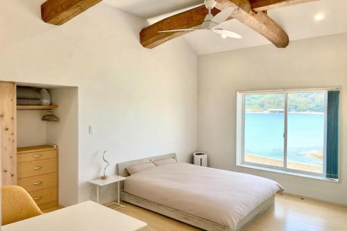 a bedroom with a bed and a large window at SEABASE villa at shimane in Matsue