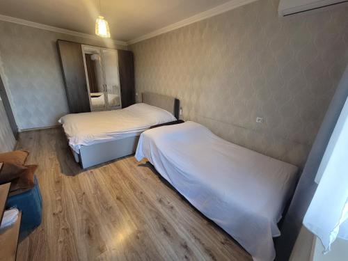 two beds in a small room with wood floors at Elan apartment in Gori