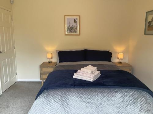 a bedroom with a bed with two night stands and two lamps at Cheshire 1 bedroom apartment - minimum 3 night stay please - garden view in Cheadle Hulme
