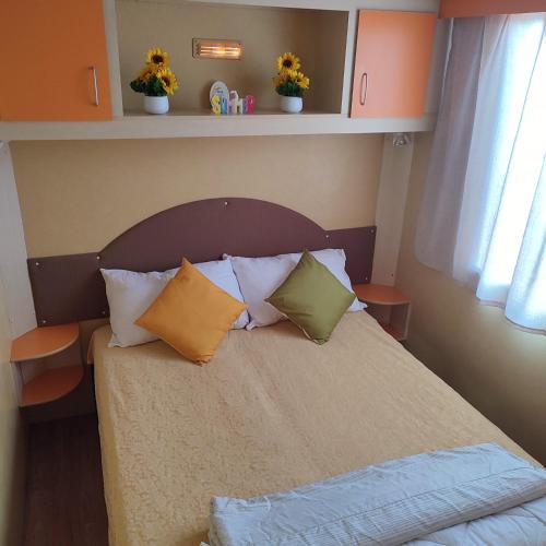a bedroom with a bed with pillows on it at GoldenSand mobilehome in Lido di Dante
