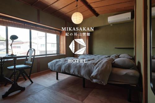 a hotel room with a bed and a desk and a desk at 三笠館Mikasakan 本館 in Kinokawa