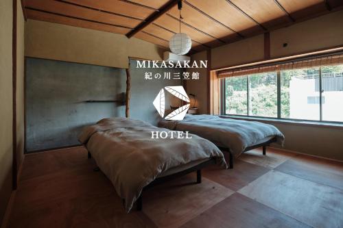 a bedroom with two beds and a large window at 三笠館Mikasakan 本館 in Kinokawa