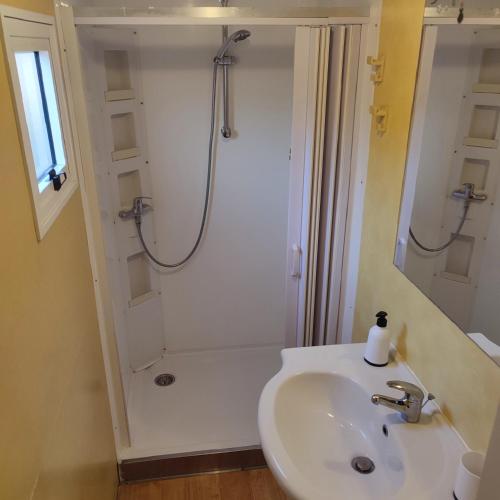 a white bathroom with a shower and a sink at GoldenSand mobilehome in Lido di Dante