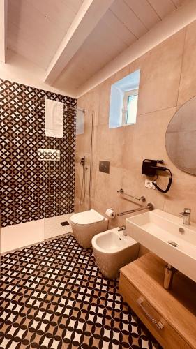a bathroom with a toilet and a sink at Eureka Apartment in Noto