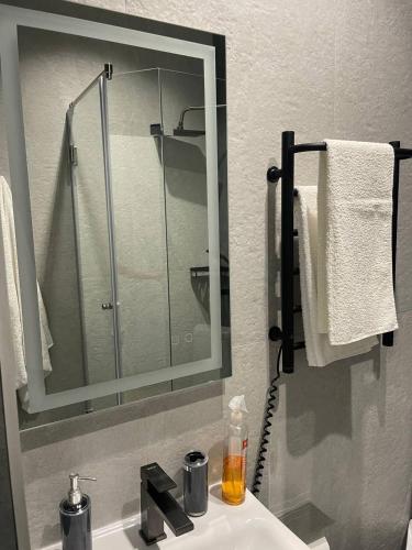 a bathroom with a sink with a mirror and a shower at Hotel GLORIA in Ceadîr-Lunga