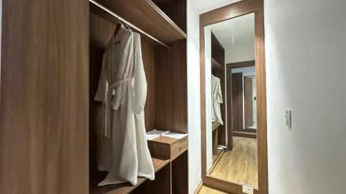 a bathroom with a large mirror and a robe at Hotel Royal Aravali in Udaipur