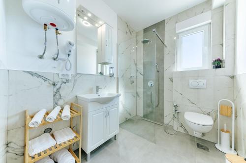 a bathroom with a sink toilet and a shower at ARA Lux Apartments in Utjeha