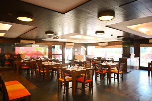 a dining room with tables and chairs in a restaurant at Ginger Vadodara ,Alkapuri in Vadodara
