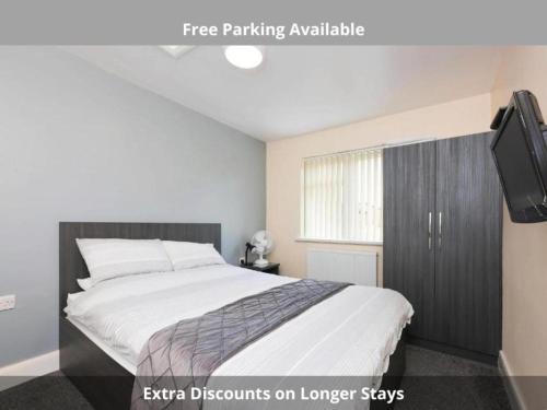 a bedroom with a large bed and a tv at OYO Honeycroft Lodge, Uxbridge in Uxbridge