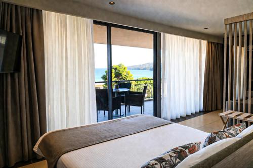 a hotel room with a bed and a view of the ocean at Apollon Hotel in Tolo
