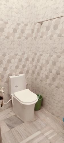 a bathroom with a white toilet in a room at Nikunj dham in Vrindāvan