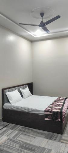 a bedroom with a bed with a ceiling fan at Nikunj dham in Vrindāvan