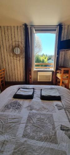 a bedroom with a large bed and a window at chambre dhote condat sur ganaveix in Condat-sur-Ganaveix