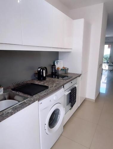 a kitchen with a washing machine and a sink at Modern Studio apartment Armonia Court in Paralimni