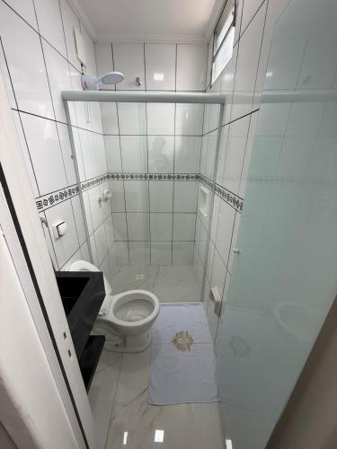 a white bathroom with a toilet and a shower at Hotel Impactus Santo Amaro in São Paulo