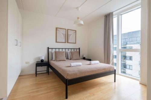 a bedroom with a bed and a large window at Amazing Two Bedroom Apartment in Urban Area in Copenhagen