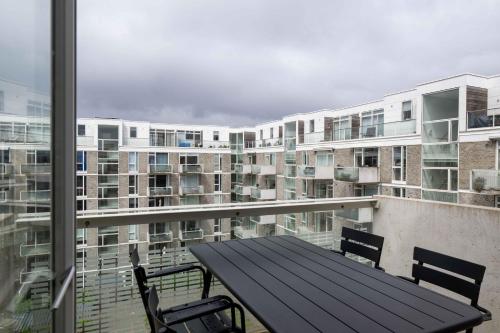a balcony with a table and chairs and a building at Amazing Two Bedroom Apartment in Urban Area in Copenhagen