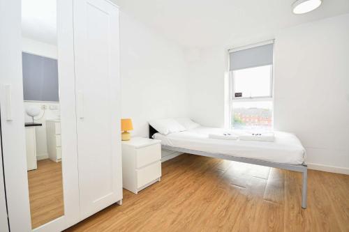a white bedroom with a bed and a window at Cosy Budget En-suites, Optional Kitchen, Liverpool in Liverpool
