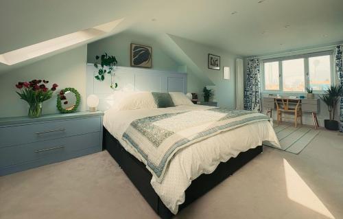 a bedroom with a large bed and a desk and a table at The Nest in Bristol