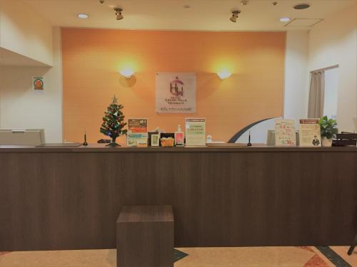 a lobby with a counter with a christmas tree on it at Hotel Crown Hills Yamagata in Yamagata