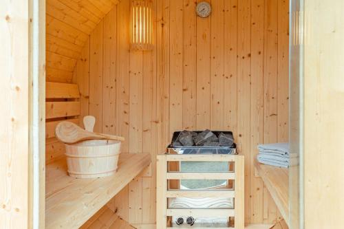 a wooden sauna with a tub and a bucket at Green Eifel Casa in Feusdorf